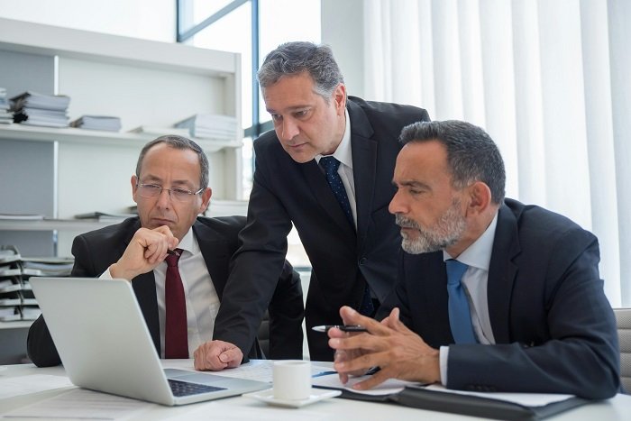 Business professionals reviewing advisory strategy on a laptop